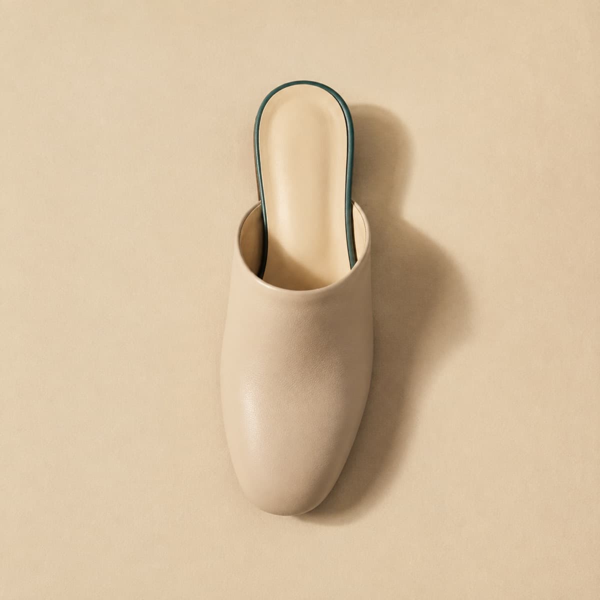 Mule Closed Toe, photographed from above against a sand-beige background