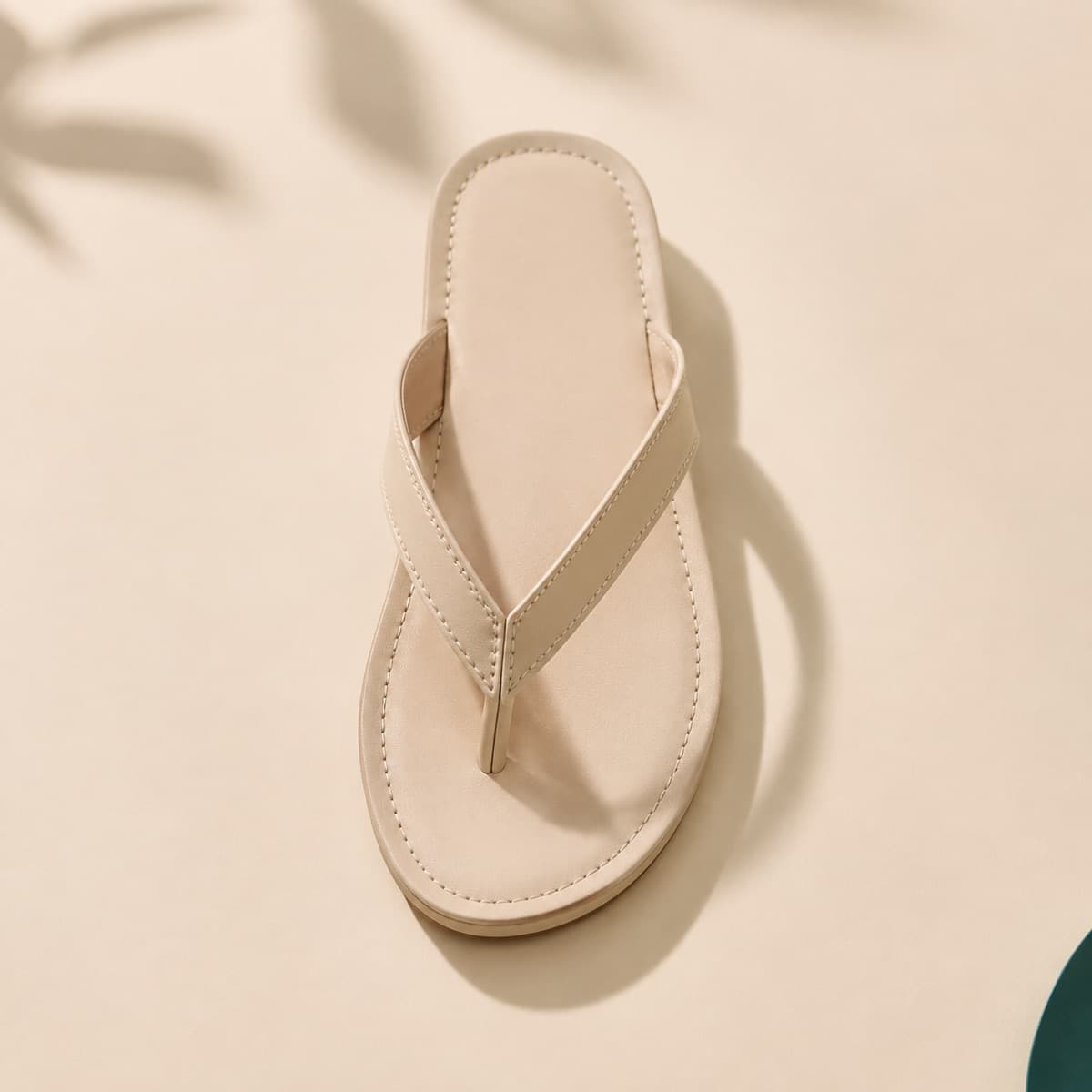 Toe-Post Leather, photographed from above against a sand-beige background